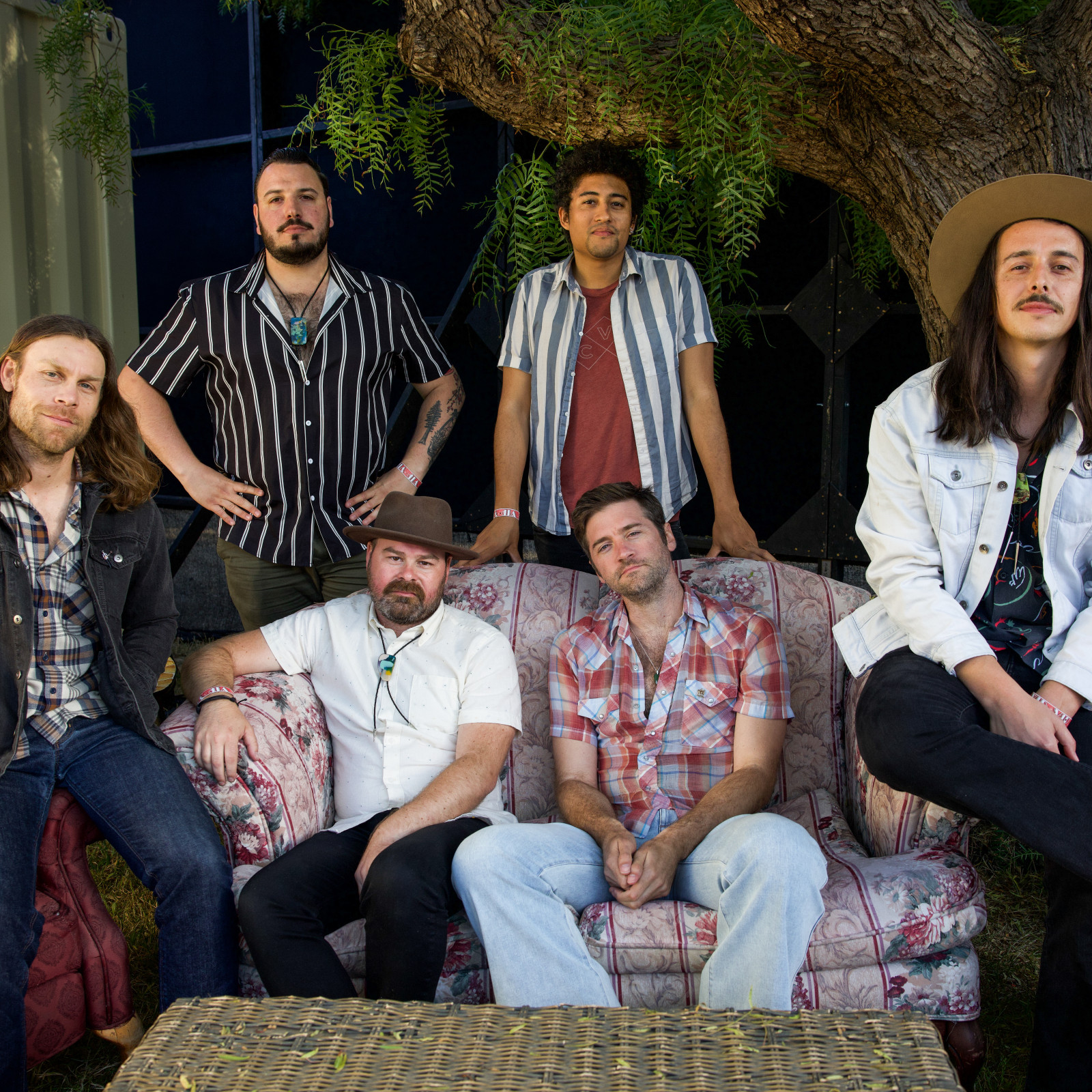 John Craigie with the Coffis Brothers, sitting casually on and around a couch.